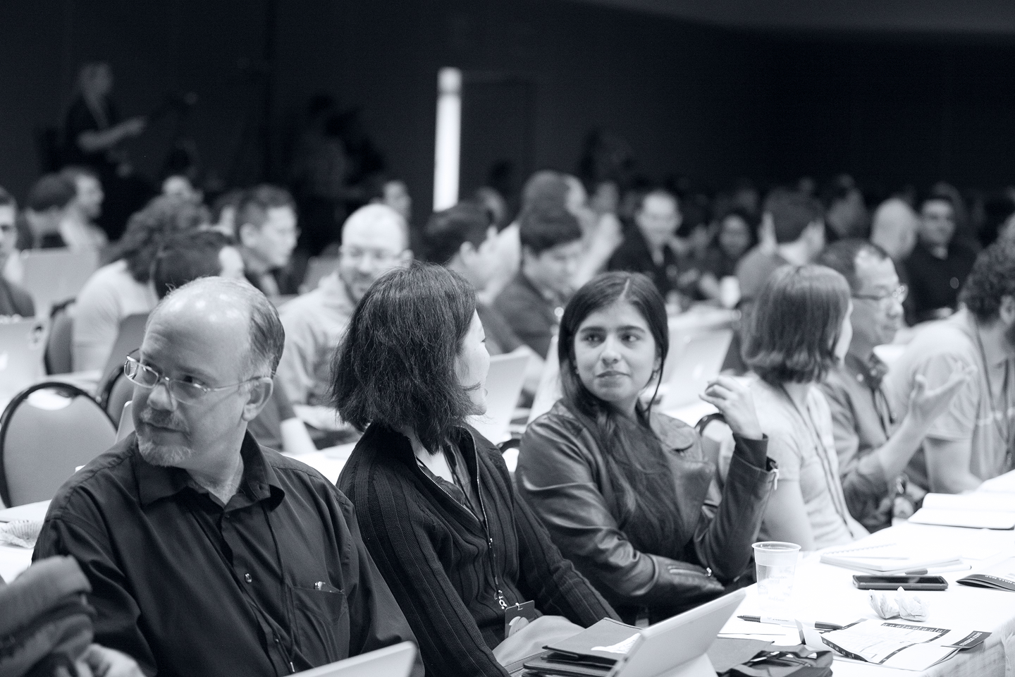 Seated conference participants talking with one another